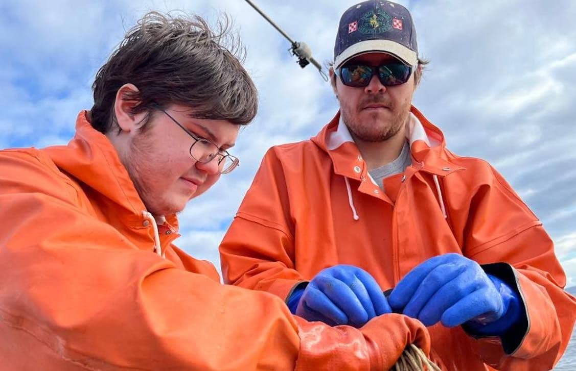 The Carpenter Family stand aboard their fishing vessel