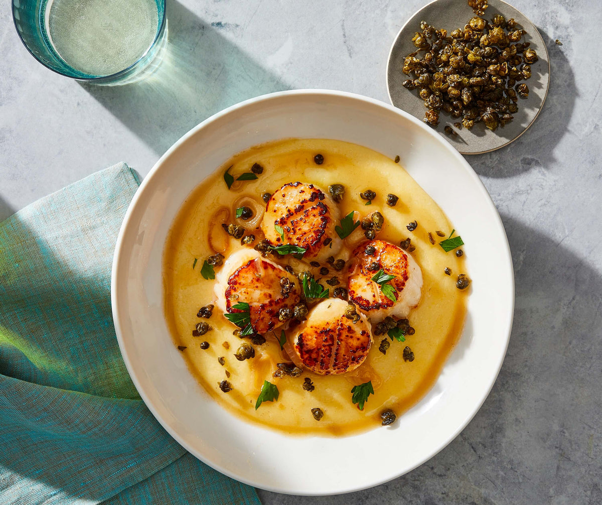 seared scallops in a bowl over polenta