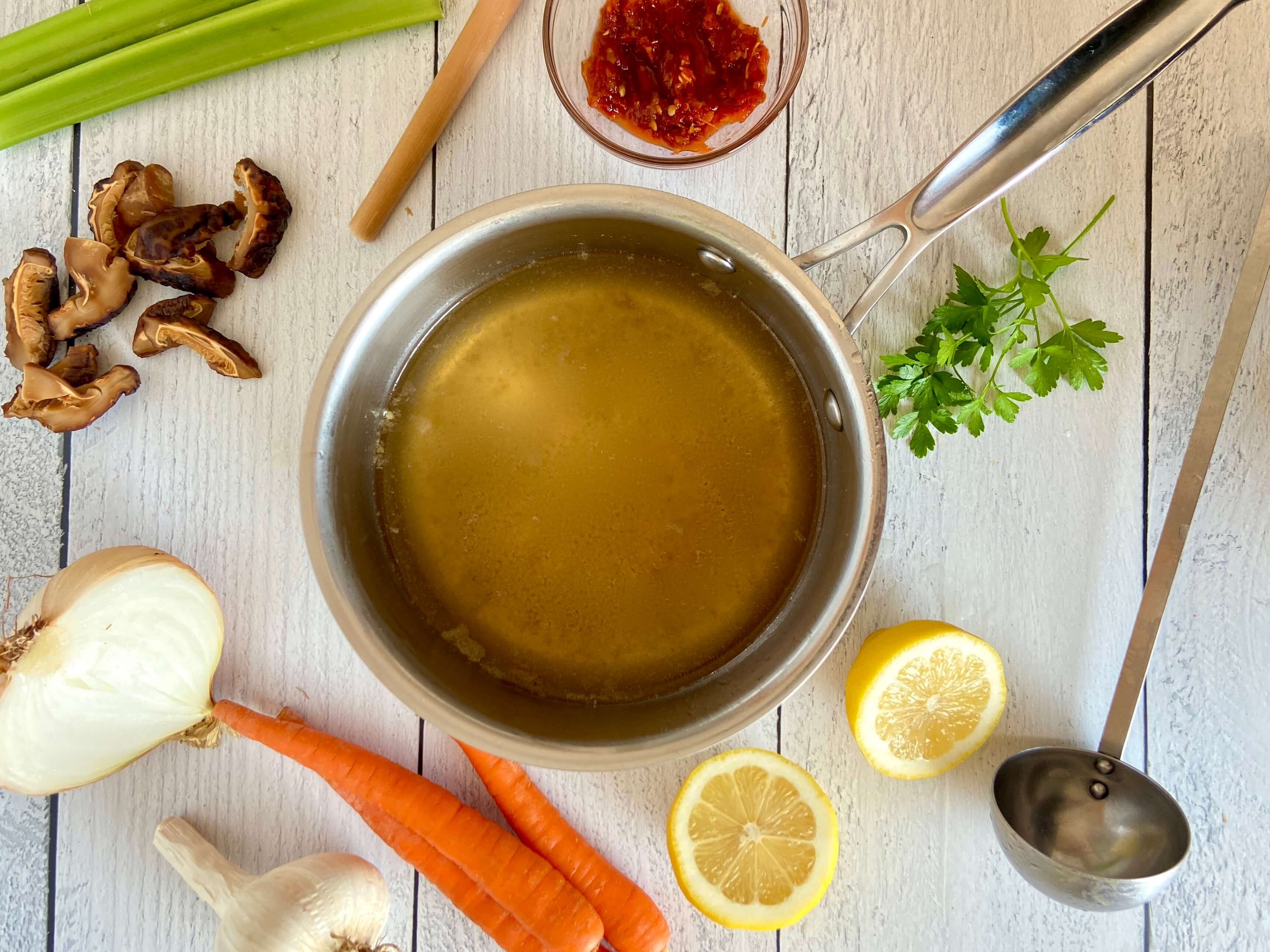 pot of soup with vegetables on a board