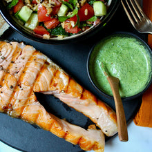 A plate of grilled king salmon steak with taboulleh
