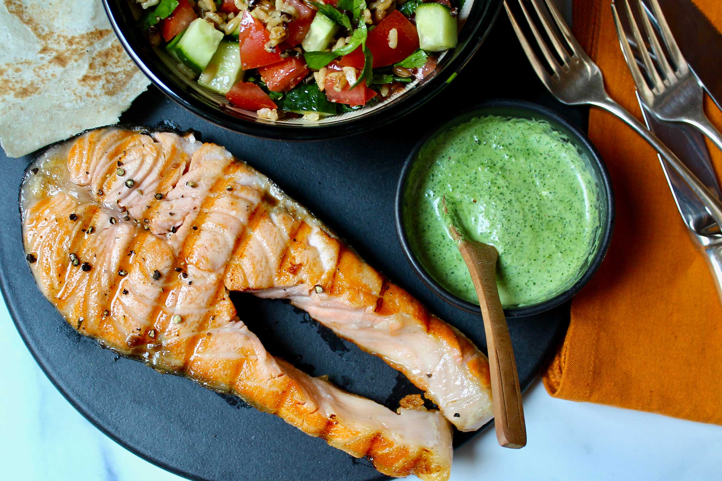 A plate of grilled king salmon steak with taboulleh